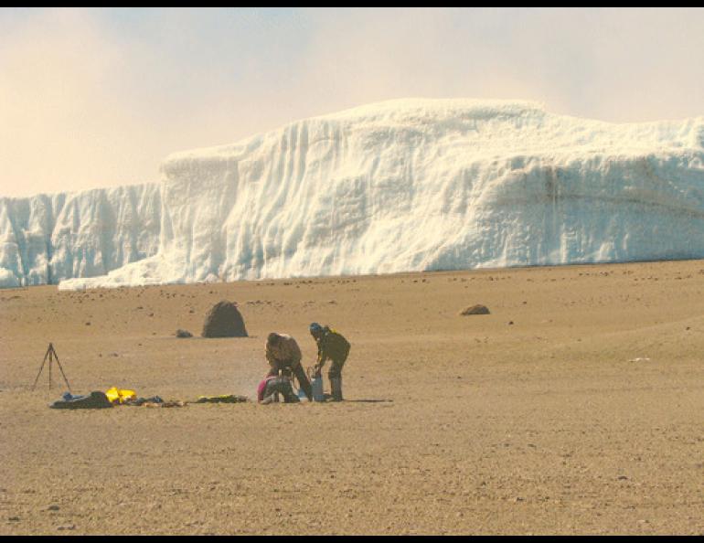 Kenji Yoshikawa, Kenji Narita, and guide Romli Otto who helped with a climb up Mount Kilimanjaro drill a permafrost monitoring hole near the volcano’s summit. In the background is Furtwängler Glacier, a remnant of a large icecap that used to cover Kilimanjaro’s summit. Photo by Mike O’Toole.
