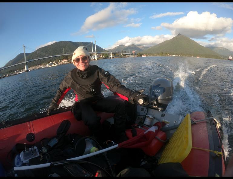 Oregon State University biologist and diver Sarah Gravem motors past Sitka on her way to a kelp forest she is monitoring. Photo by Jake Metzger.