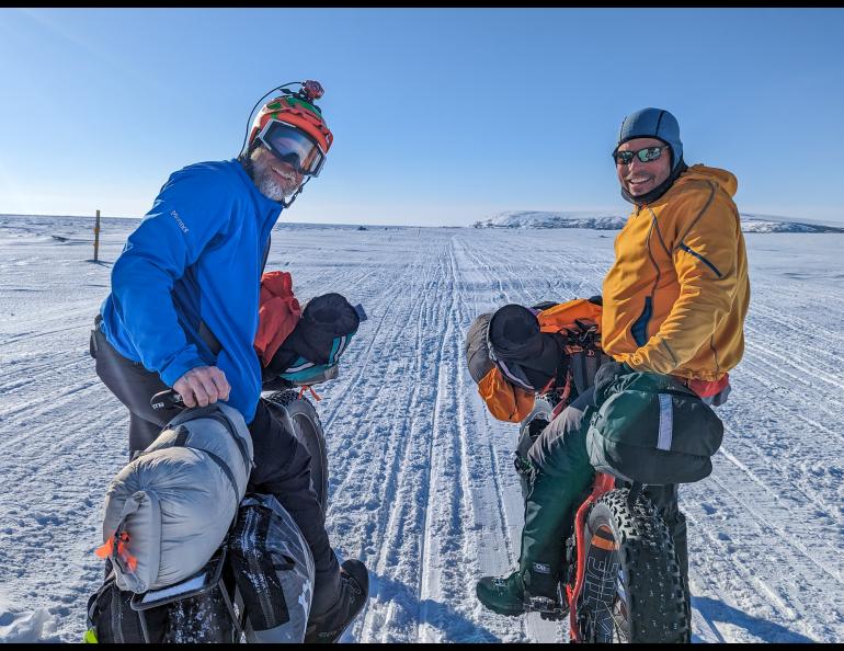 Jamie Hollingsworth, left, and Bill Fleming pause with Cape Nome in the distance, within 10 miles of the finish of their 1,000-mile ride on the Iditarod Trail. Photo by Jay Cable.