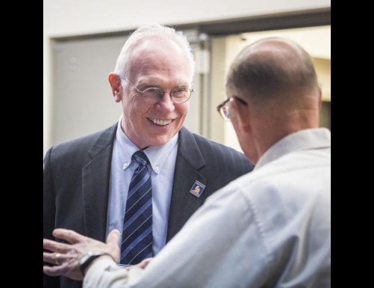 Larry Hinzman speaks with climate scientist John Walsh at a meeting on the University of Alaska Fairbanks campus. UAF photo by JR Ancheta.