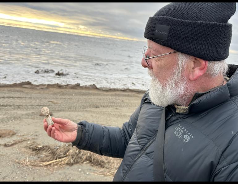 Rick Knecht holds a human figure that he found on the beach near the village of Quinhagak on Oct. 24, 2025. Photo by Alice Bailey.