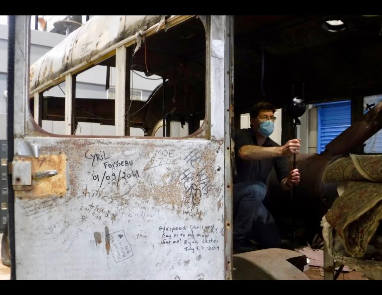 Roger Topp of the UA Museum of the North captures images inside the former Fairbanks city bus that gained fame as the final resting place of Christopher McCandless. Photo by Ned Rozell.