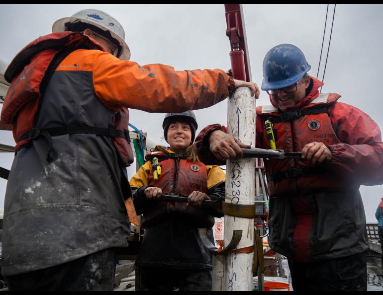 UAF master’s degree student Sara Datson, facing camera, helps retrieve a core of the ocean floor west of Nome during a summer 2023 cruise of the University of Alaska Fairbanks research ship Sikuliaq. Photo by Natalie Buttner.