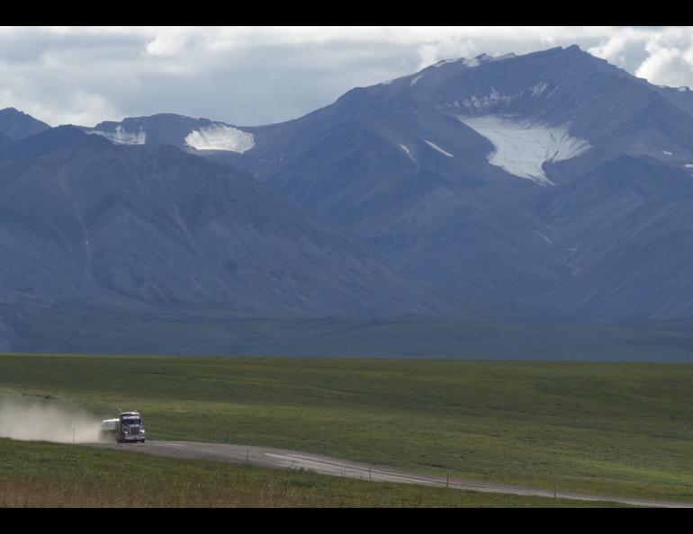 A trucker drives the Dalton Highway toward Prudhoe Bay beneath the withering Gates Glacier. Photo by Ned Rozell.