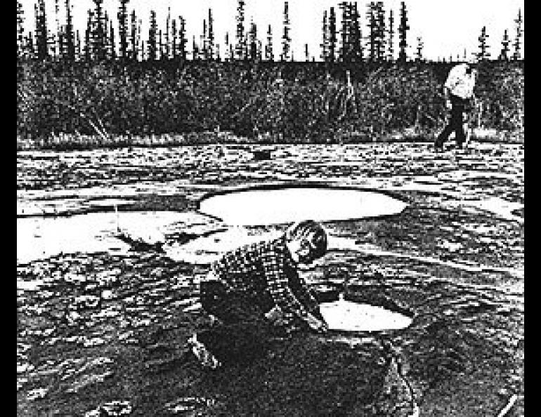 Budding scientist, Tommy Pollard, tests the water bubbling up through a vent atop Tolsona Mud Volcano Number One.