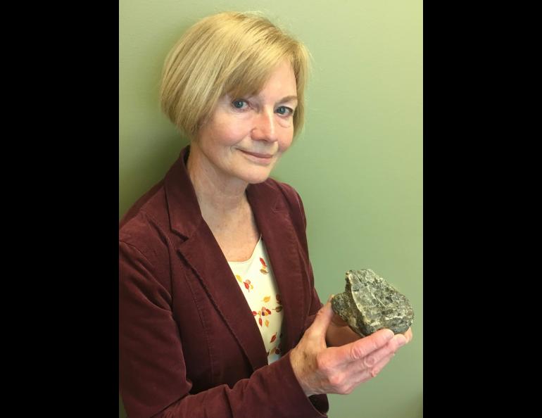 Geologist Marti Miller with a 2-billion-year-old rock she collected near Iditarod. Photo by Adrian Bender.