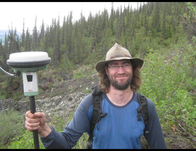 Ronnie Daanen measures the movement of a frozen debris lobe off the Dalton Highway north of Coldfoot in 2014. Photo by Margaret Darrow.