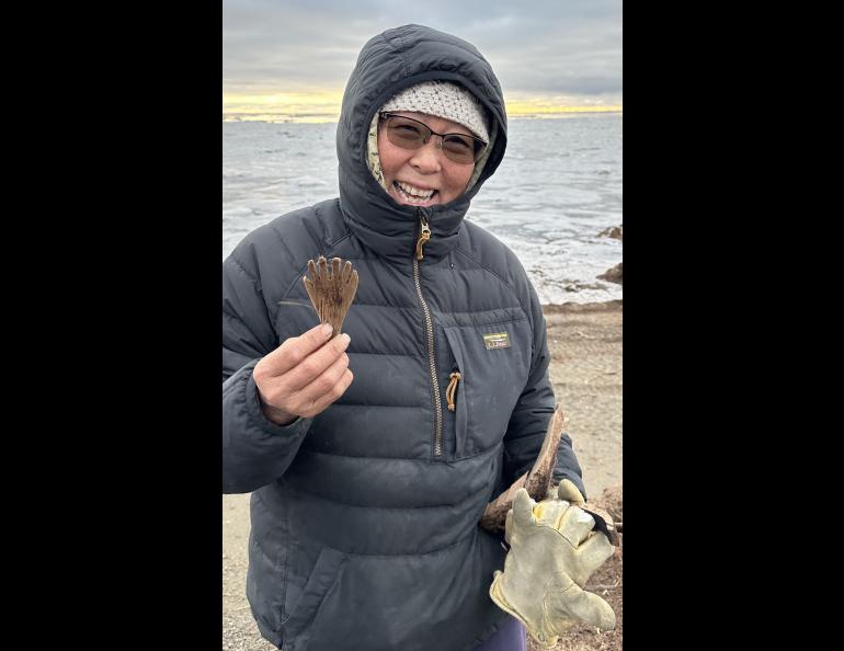 Quinhagak resident Sarah Brown holds a mask attachment she found on the beach on Oct. 24, 2025. This item might represent a hand or fin of an animal or spirit being. Photo by Alice Bailey.