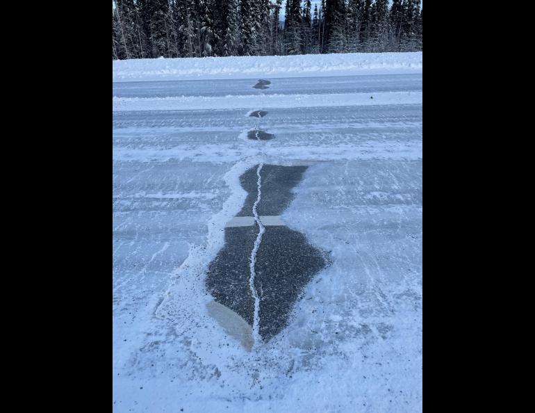 A Fairbanks highway after a midwinter rain event. The crack in the asphalt pavement provided a weak point in the almost-uniform ice formation on the roadway. The bare areas are providing a bumpy ride for Fairbanks drivers, who may endure the conditions until April. Photo by Tom Douglas.