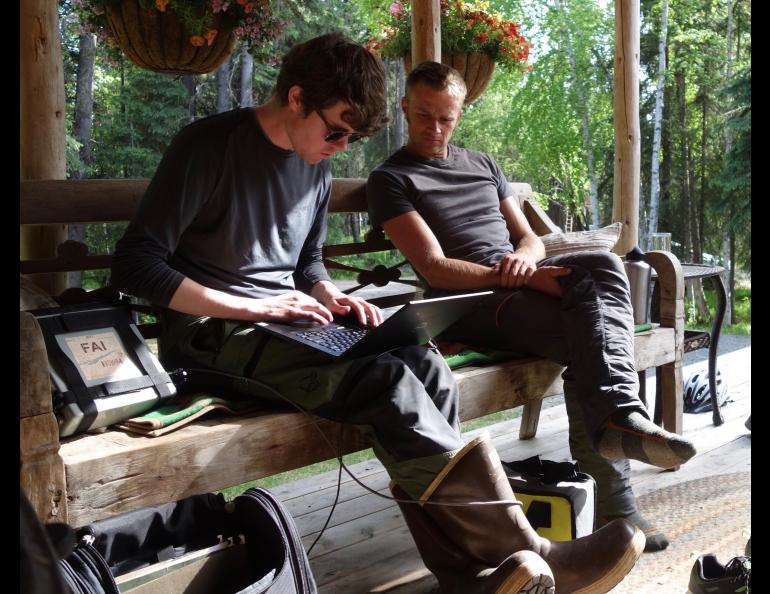 On a Fairbanks homeowner’s porch, Nicholas Hasson, left, and Jason Clark of UAF review results from permafrost investigations. Photo by Ned Rozell.