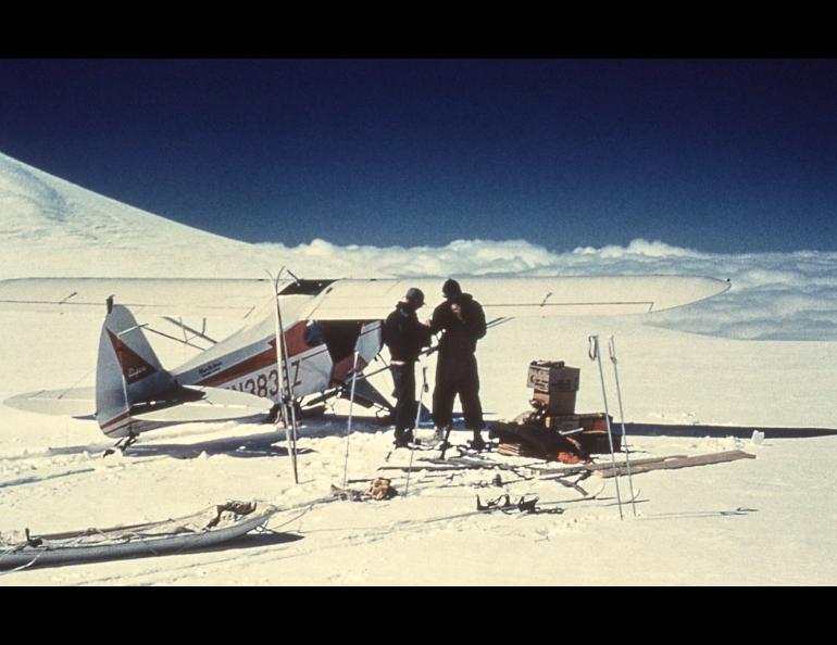 Carl Benson, right, and pilot Jack Wilson of Copper Center confer after landing near the summit of 14,000-foot Mount Wrangell. Photo courtesy of the UAF Geophysical Institute.