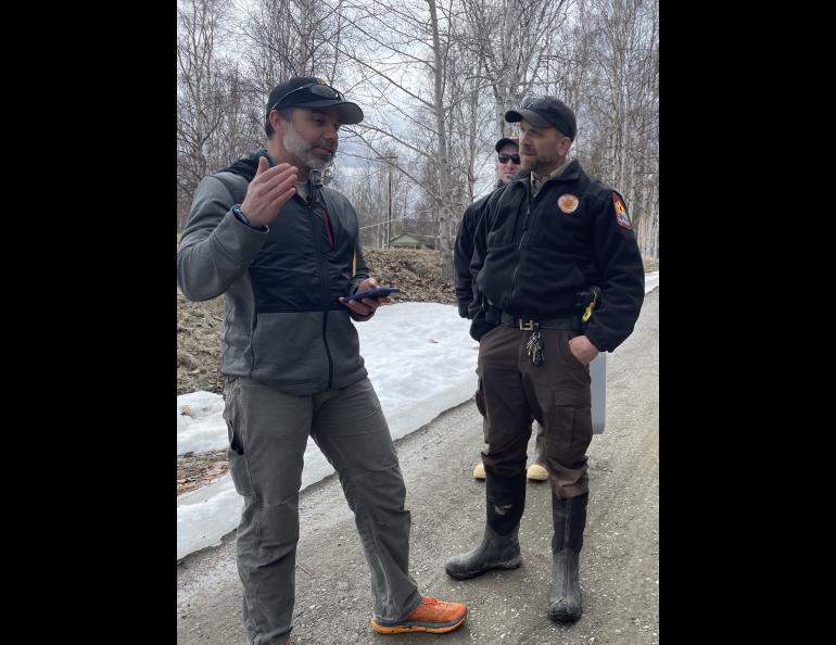 Crane Johnson, left, of the Alaska-Pacific River Forecast Center in Anchorage talks with Nate Becker, the village public safety officer for the town of Eagle, on May 13, 2023, after floodwaters pushed Yukon River ice into the town. Photo by Ned Rozell.
