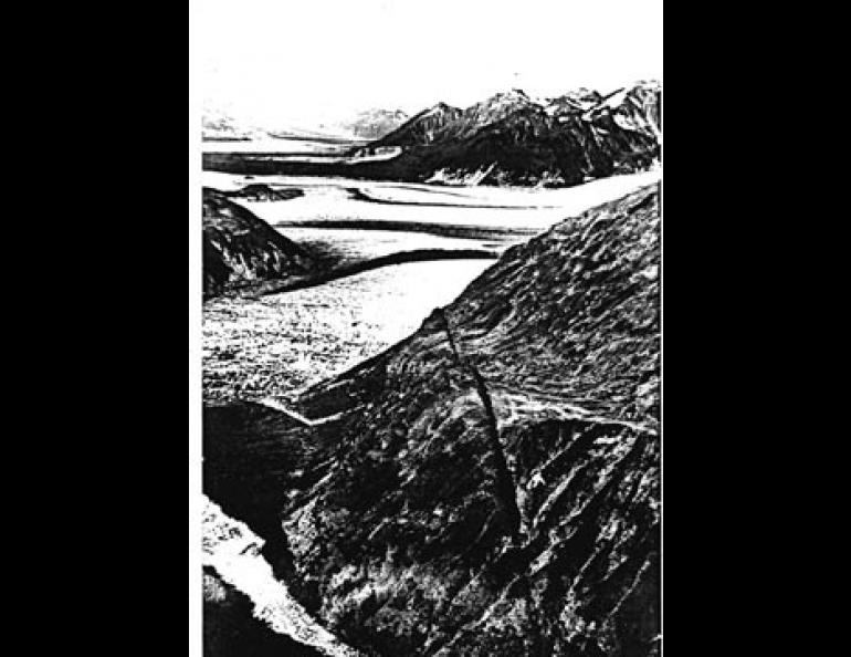 Looking to the northwest, the trace of the Fairweather fault can be seen passing over the shoulder of the ridge in the middle foreground. Beyond lie the Grand Plateau Glacier and the St. Elias Mountains. (Photo by Gil Mull.)