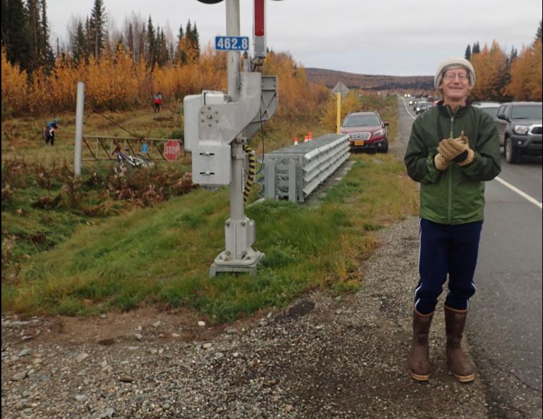 Multiple-time race champion Stan Justice encourages runners at a road and railroad-track crossing in a recent Equinox Marathon. Photo by Ned Rozell.