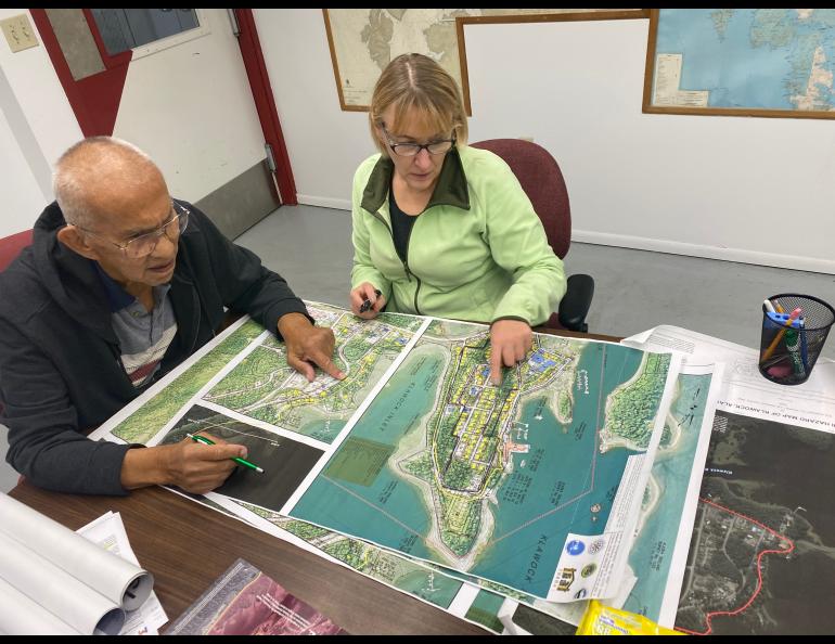 Two people look at a map in an office