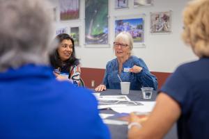 Anupma Prakash (left) and Sue Royston reviewing photos at the 2026 GI reunion. Photo by Eric Marshall