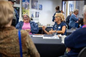 Kathe Rich (left) and Jackie Dashiell chat with friends at the 2026 GI reunion. Photo by Eric Marshall