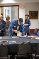 Steve Estes reviews a binder full of archived GI reports at the 2026 GI reunion. Photo by Eric Marshall