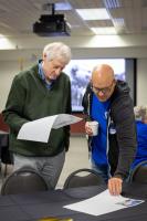 Brenton Watkins, left, reviewed photos with Mitch Robinson at the 2026 GI reunion. Photo by Eric Marshall