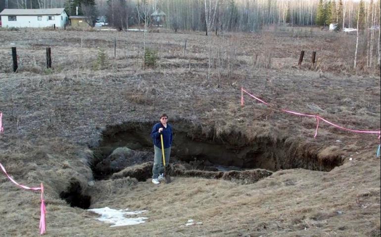 UAF researcher Vladimir Romanovsky poses near Fairbanks, Alaska in a place where permafrost has thawed, causing a surface disruption. Photo courtesy V. Romanovsky.