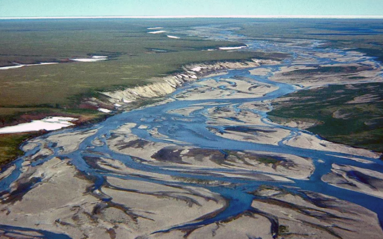 The Jago River flows north through the Arctic National Wildlife Refuge to the Arctic Ocean, with its ice pack visible in the distance in the 1990s. Image by Gil Mull, Alaska DGGS.