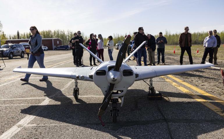 Event participants gather around the Sentry unmanned aircraft of the UAF Alaska Center for Unmanned Aircraft Systems Integration after a successful flight May 22, 2022, at Fairbanks International Airport. Photo by JR Ancheta/UAF Geophysical Institute