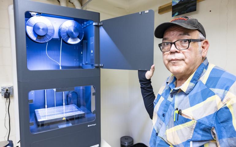 Jesse Atencio, a fabricator in the Geophysical Institute's Machine Shop, shows the new metal 3D printer. Photo by JR Ancheta