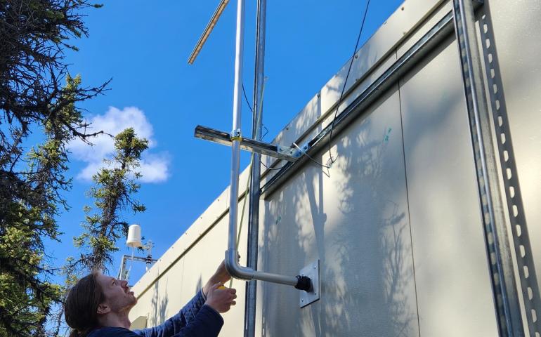 Graduate student James Campbell installs the sampling inlet for the X-act instrument outside at the Delta Junction network site. Photo courtesy of Jingqiu Mao.