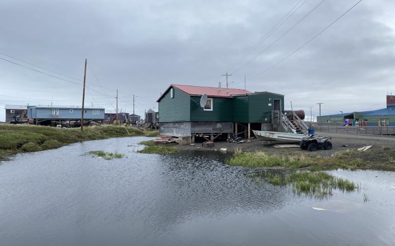 The combined effects of climate change and infrastructure development on ice-rich permafrost in Point Lay have resulted in severe thaw subsidence and surface water ponding that is destabilizing homes. Photo by Jana Peirce.
