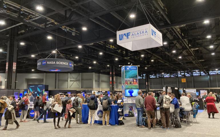Visitors gather at the University of Alaska Fairbanks exhibitor booth at the AGU Fall Meeting 2022 in Chicago, IL. UAF GI Photo by Kelly Eagan.