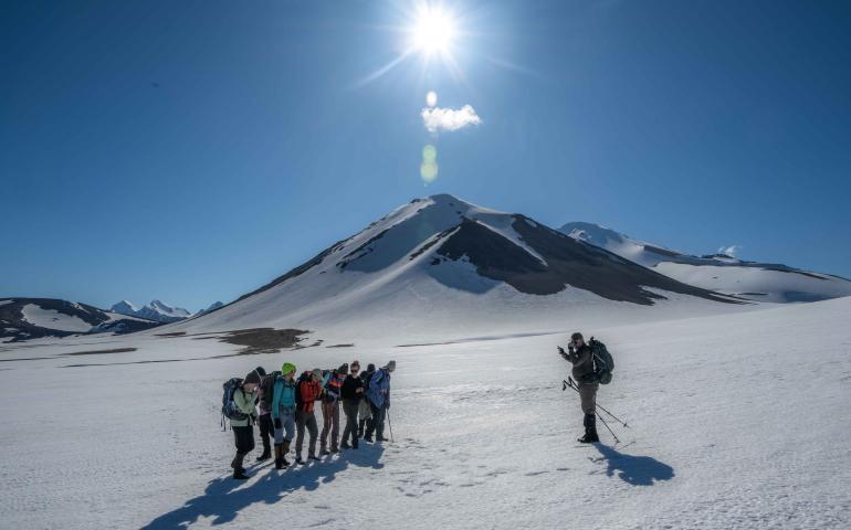 Research associate professor Pavel Izbekov photographs students on the return from a day hike with Novarupta in the background. Photo by Seth Adams