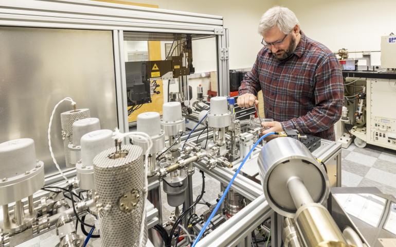  Research assistant professor Florian Hofmann of the UAF Geophysical Institute’s Geochronology Lab works on the lab’s argon mass spectrometer. Photo by JR Ancheta