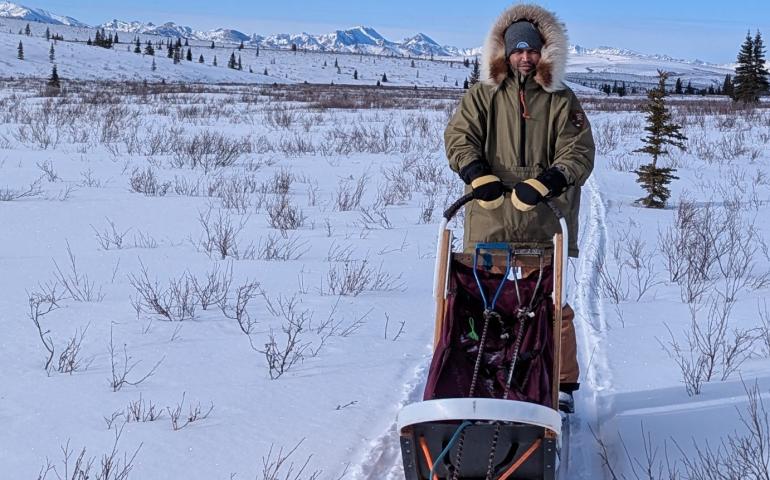 UAF doctoral student Kaytan Kelkar in Denali National Park in March for work on continuing permafrost research. Kelkar rode a sled towed by a National Park Service dog team. Photo courtesy of Kaytan Kelkar