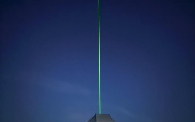 A light beam produced by the new lidar emerges from the dome at the Subauroral Geophysical Observatory at Gakona. Photo by Mike Roddewig