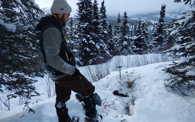 UAF graduate student Cole Richards installs a high-sampling seismic sensor in February 2019. It is one 400 placed along the Parks Highway following the 2018 magnitude 7.1 Anchorage earthquake. Graduate student Bella Seppi would later use the sensor data in her aircraft research. Photo by Carl Tape