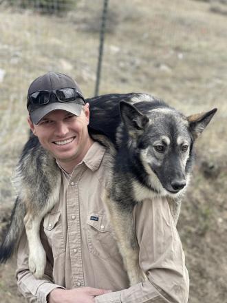 One of Michael Rottewig’s sled dogs, Raven, likes to be carried around on his shoulders. Photo courtesy Michael Roddewig