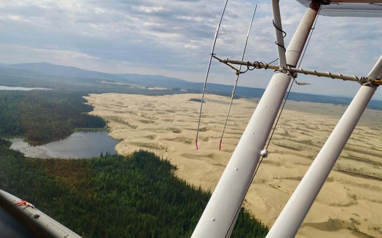 The Nogahabara Dunes spill into a lake 35 miles west of the village of Huslia as seen from the back seat of a Super Cub piloted by Brad Scotton of the U.S. Fish and Wildlife Service based in Galena. Photo by Ned Rozell.