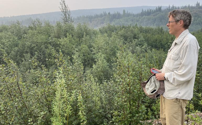 Seismologist Carl Tape stands at the site of Dome City in summer 2025. Dome City ghosted out many years ago, but not before miners unearthed many fossils, some of which they donated to the University of Alaska. Photo by Ned Rozell.