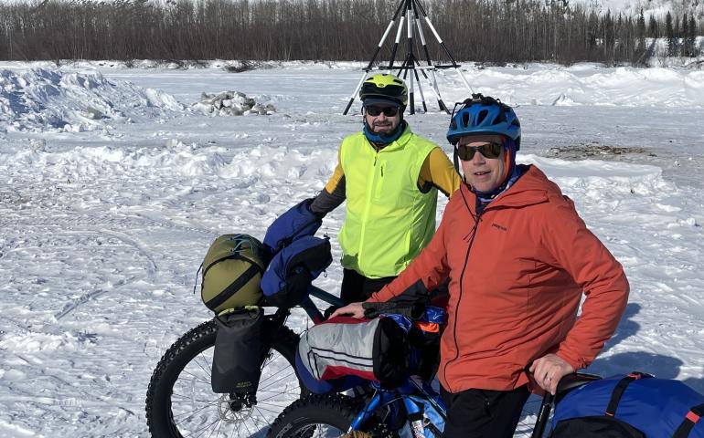 Forest Wagner, left, and Ned Rozell pause in front of the tripod on the ice of the Tanana River at the town of Nenana. When river ice breaks up, whoever guesses the exact time the tripod falls and pulls a cable will be the winner of the Nenana Ice Classic. Photo by Ned Rozell.