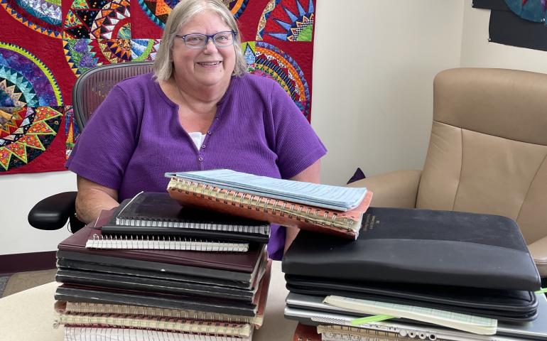 In June 2025, Kathe Rich sits in her office at Poker Flat Research Range behind notebooks she has filled with details of her 35 years at the rocket-launching facility. Photo by Ned Rozell.