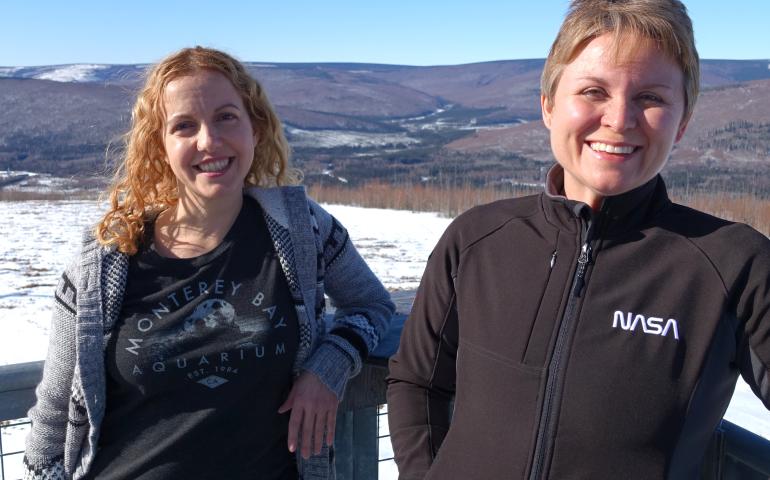 Astrophysicists Lindsay Glesener, left, and Sabrina Savage enjoy the sunshine on an observation deck at the Neil Davis Science Center on a hilltop at Poker Flat Research Range north of Fairbanks. Photo by Ned Rozell.