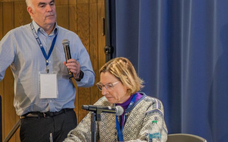 Mark Myers, commissioner of the U.S. Arctic Research Commission, leads a discussion on the potential of geologic hydrogen at a conference in Fairbanks recently. Alaska State Senator Cathy Giessel takes notes. Photo by Eric Marshall.