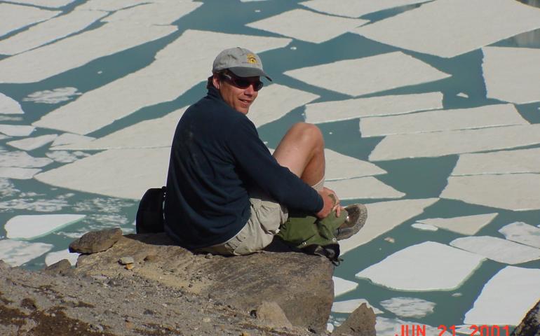Ned Rozell sits at the edge of the volcanic crater on Mount Katmai during a trip to the Valley of 10,000 Smokes in 2001. Photo by John Eichelberger.