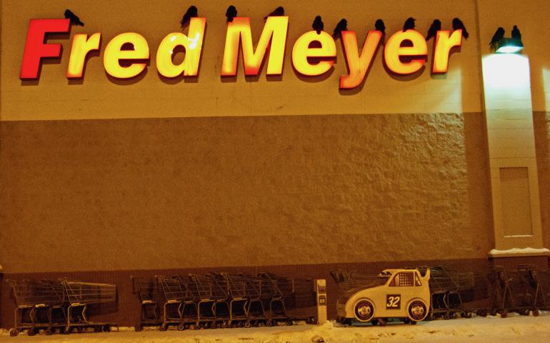 Ravens roost for the night on the letters of a grocery store in Fairbanks. Photo by Douglas Yates.