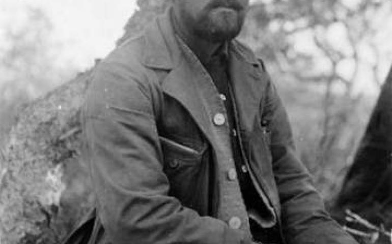 In 1917, botanist and expedition leader Robert Griggs sits at the National Geographic Society Base Camp in what later became Katmai National Park and Preserve, Alaska. Photo by D.B. Church.