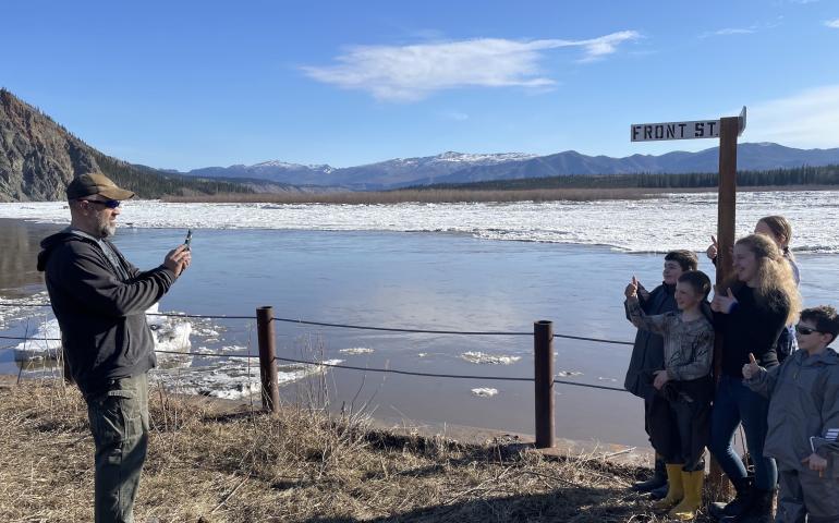 Ryan Becker, a teacher at the Eagle school, takes a photo of his students as part of a continuing Yukon River ice study on May 12, 2023. Photo by Ned Rozell.