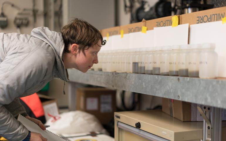 Steffi O’Daly looks at sea water samples from Bering Strait aboard the UAF research ship Sikuliaq. Photo by Andrew McDonnell.