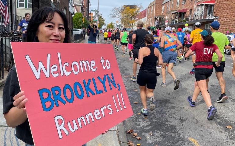 A woman welcomes runners to Brooklyn during the New York City Marathon on Nov. 6, 2022. Photo by Ned Rozell.