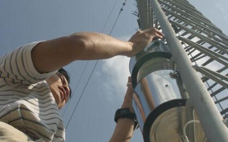  Photo: Ted Wu, an environmental toxicologist studying at the University of Alaska Fairbanks, hangs a device to capture pollutants in Alaska air at Poker Flat Research Range north of Fairbanks. Ned Rozell photo. 