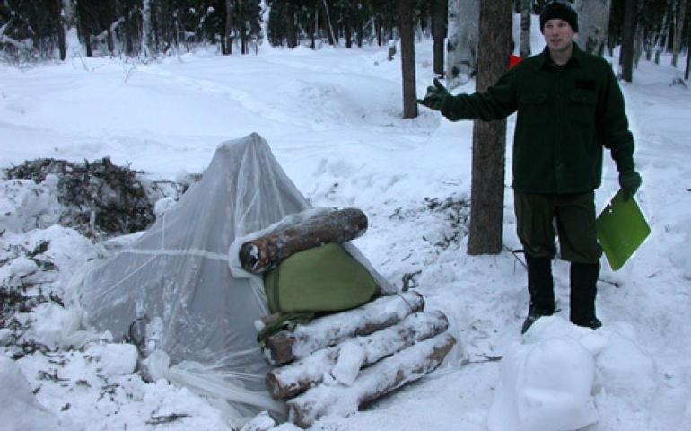  Senior Airman Jason Clapper shows the basic structure of a thermal A-frame shelter during Arctic Survival Training School class on Eielson Air Force Base. photos by Ned Rozell 